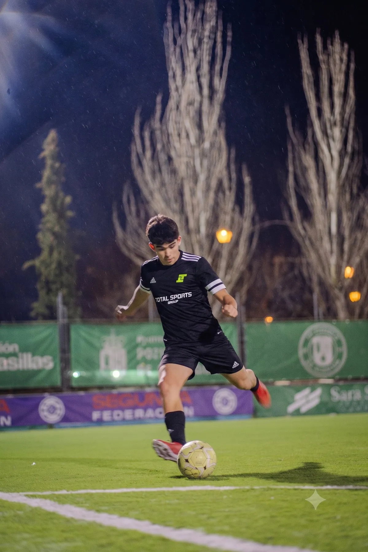 A player striking the ball under floodlights during a night match